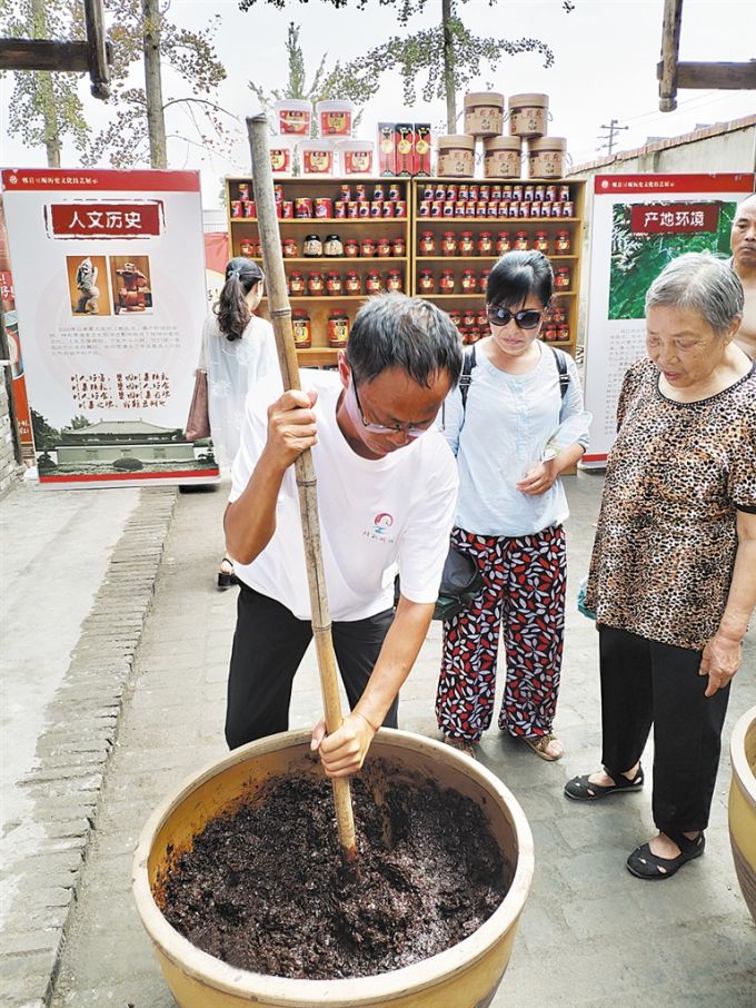 游客在“乡村十八坊”体验手工制作豆瓣